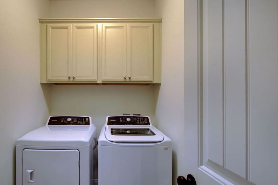 Laundry room with washer, dryer, iron and ironing board.