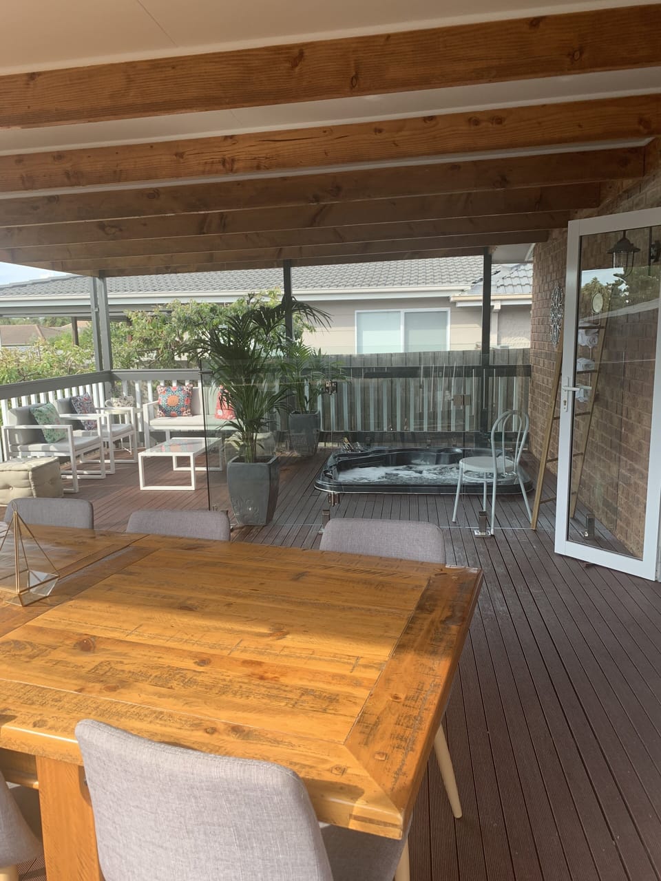 Outdoor dining table, hot tub and outdoor lounge.