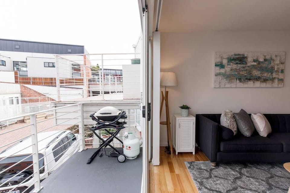 The balcony off the living room is furnished with alfresco seating and a Weber BBQ