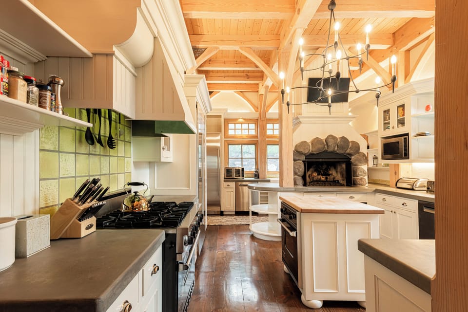 Gourmet Kitchen with Viking appliances, modern stone countertops, butcher block center island, wood burning fireplace, and additional prep kitchenette with private entrance and secondary appliances