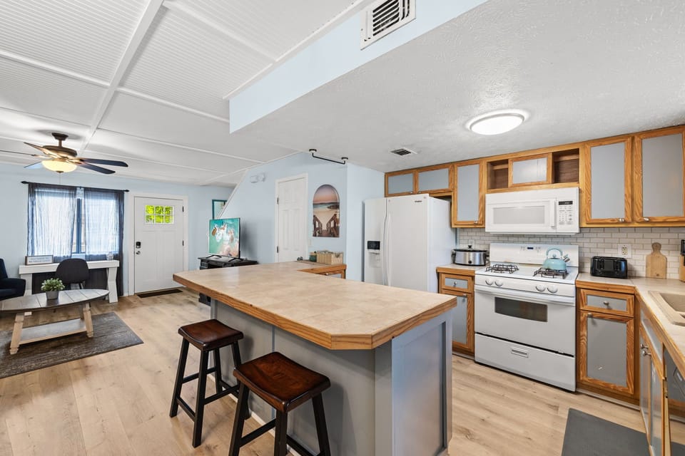 Full kitchen — gas range, fridge, microwave, breakfast bar.