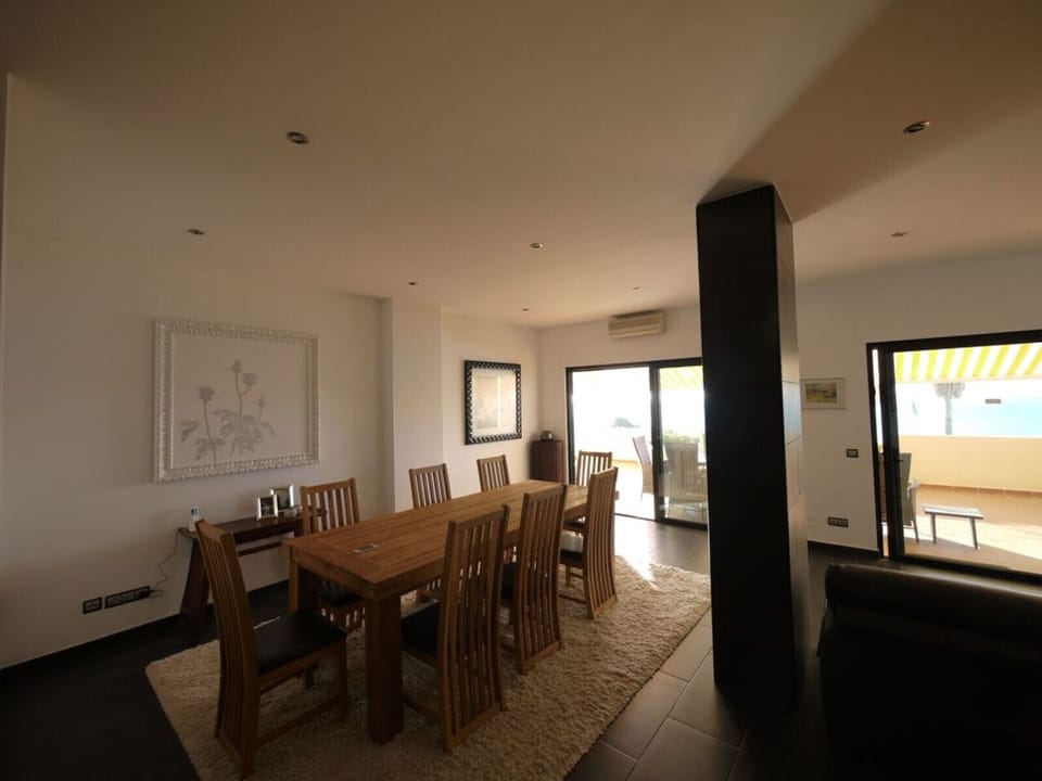 There is a dining table for eight people in the dining area of the living room.