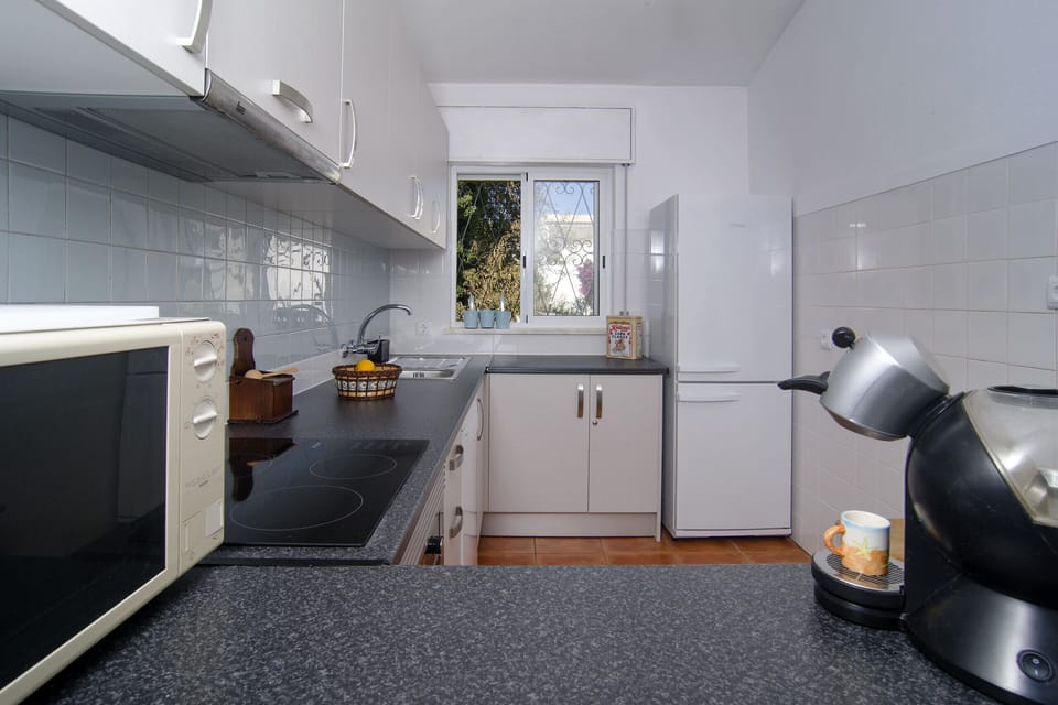 Bright kitchen with cooker, oven, microwave and coffee maker