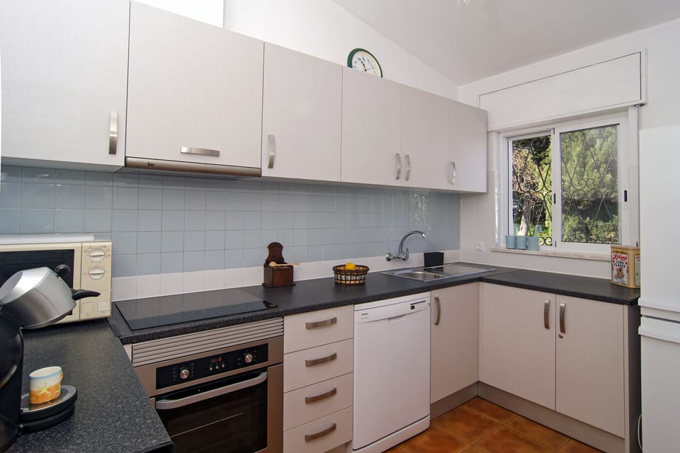 Bright kitchen with cooker, oven, microwave and coffee maker
