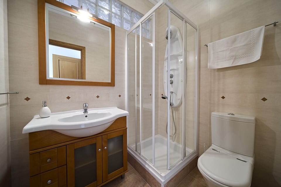 The modern bathroom in Quinta Marina has a corner shower with massage function. Furthermore, a washbasin with mirror and a toilet are installed.