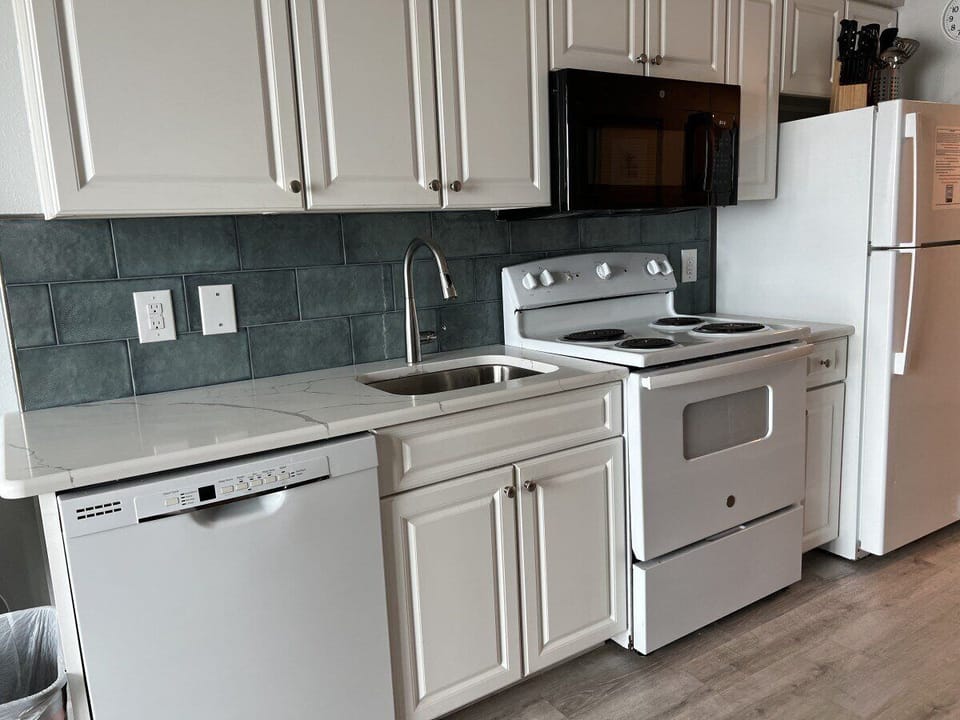 Kitchen: Bright and modern space with sleek appliances and stunning tile accents for culinary adventures!