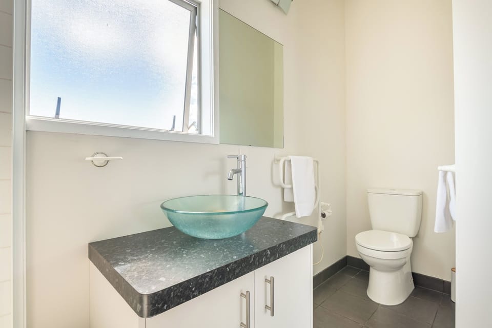 The vanity has a glass basin and a window that keeps things light.