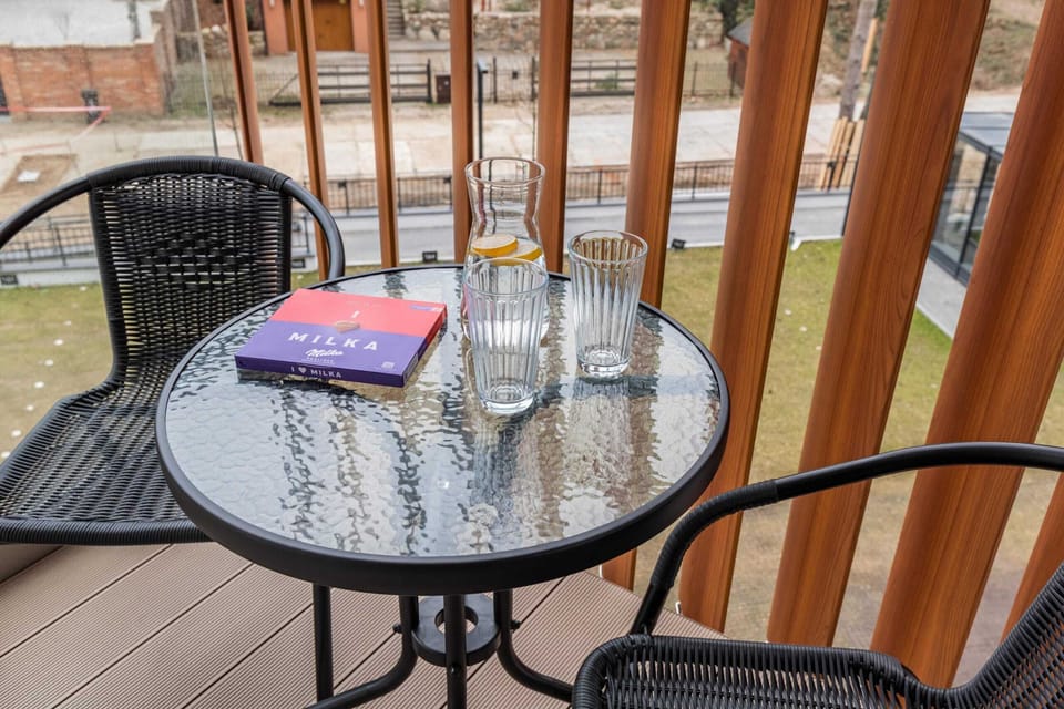 Furnished balcony with green surroundings. 