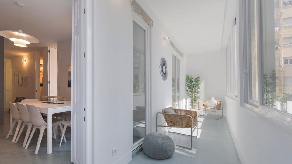 Unwind in this bright, serene enclosed balcony, perfect for starting your day with a good book or enjoying a peaceful evening. The dining area beyond offers a stylish setting for shared meals and memorable conversations.