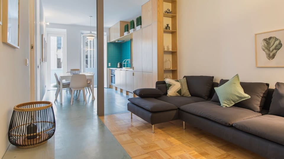 Unwind in the spacious living area, designed for comfort with a large sectional sofa, perfect for lounging after a day of sightseeing. The blend of modern and natural elements creates a serene and homely ambiance.