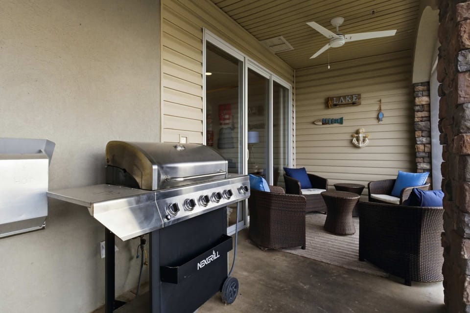 Convenient outdoor living area featuring a grill, comfortable seating, and a covered patio overlooking the waterfront perfect for relaxed meals and outdoor entertaining.
