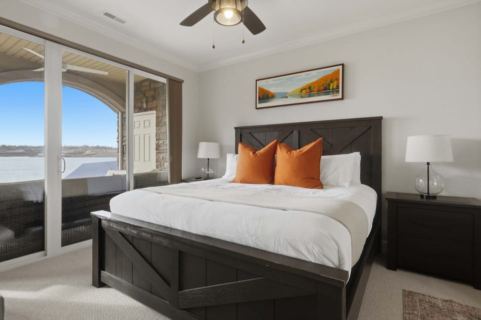 Comfortable bedroom featuring a plush bed, crisp white linens, warm wood furnishings, and beautiful outdoor views for a peaceful and relaxing stay.