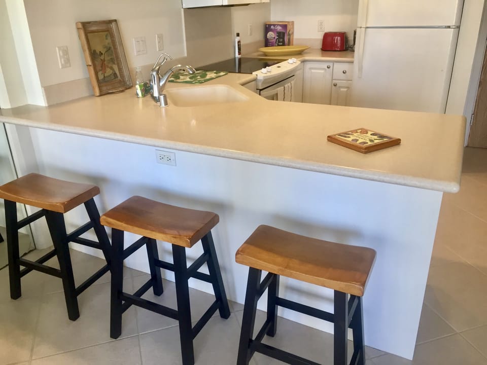 Kitchen counter with 3 bar stools.
