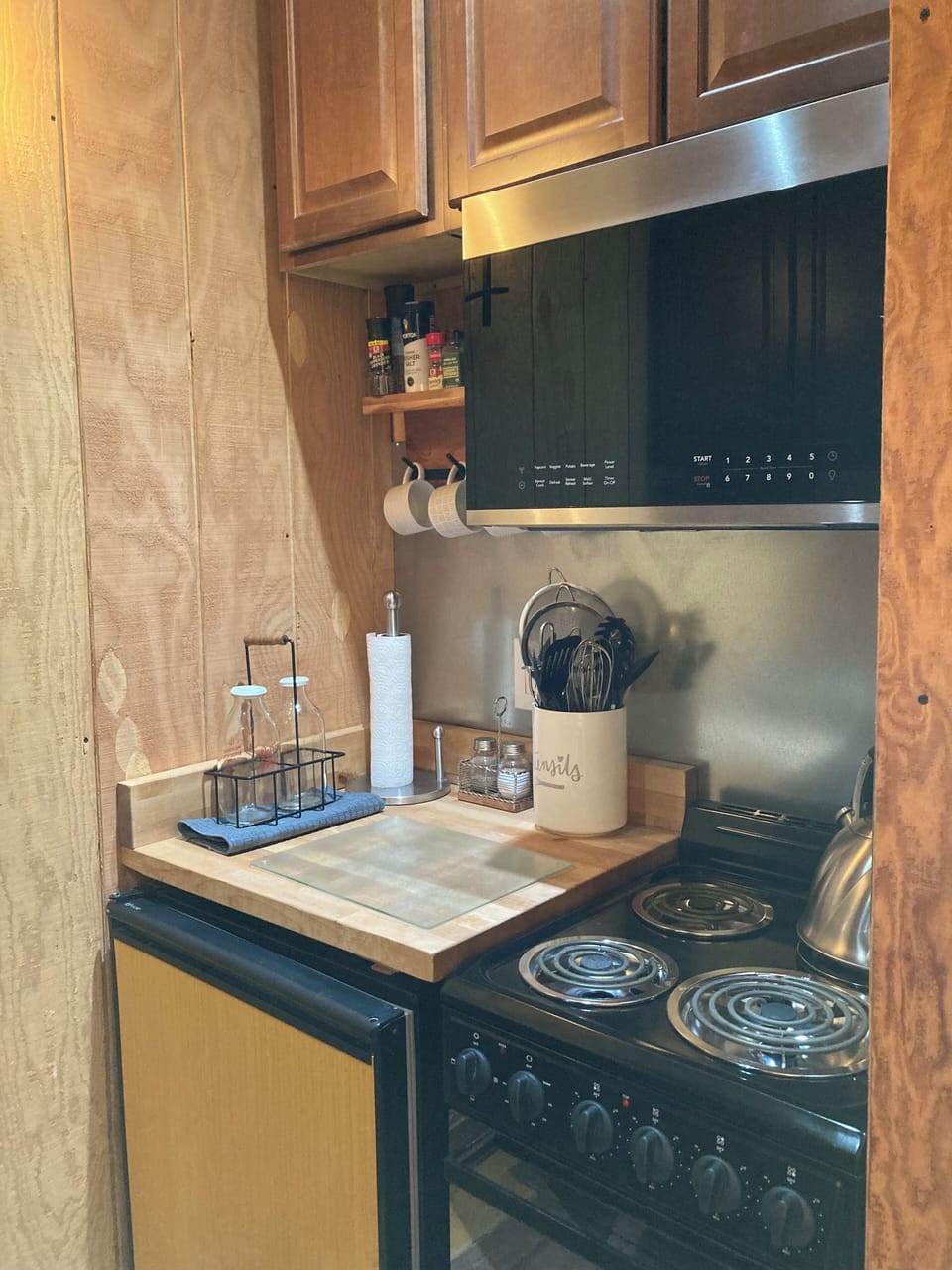 Small fully equipped kitchen with a fridge oven/stove, pots/pan & dishes 