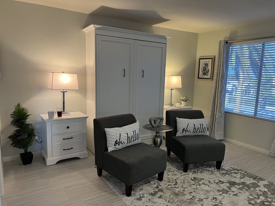 Master bedroom w/Pull down full Murphy bed and 2 chairs overlooking pool