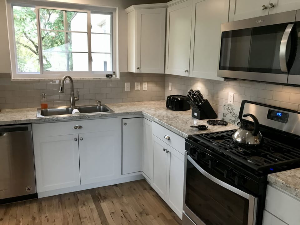 Full kitchen with cooking and dining wares, pantry, and breakfast nook.