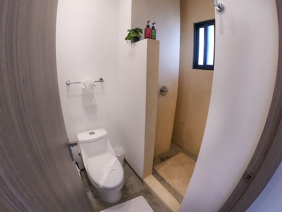 A sleek bathroom featuring modern amenities, including a toilet, in this Playa del Carmen apartment.