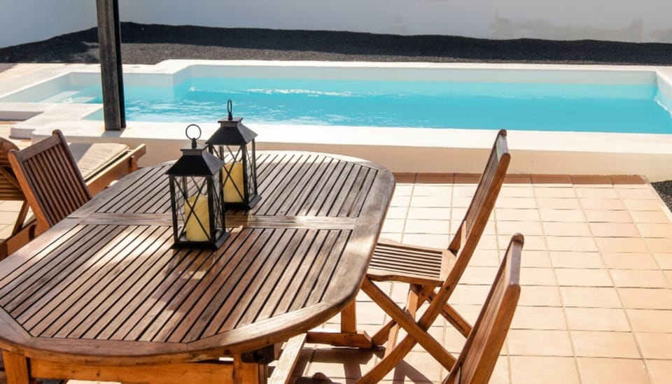 Outdoor flavors: wooden table by the pool to enjoy meals under the sun.