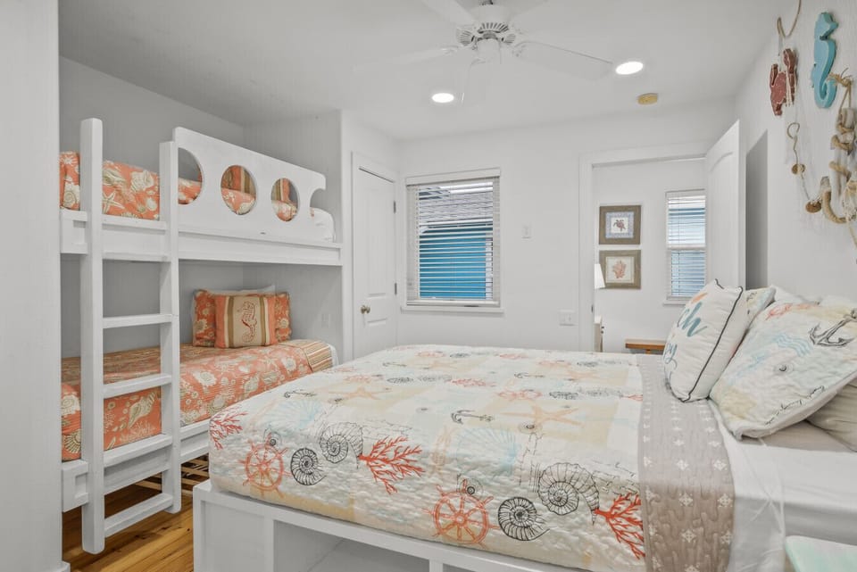 Family-friendly bedroom with queen bed and bunk beds featuring beachy décor.