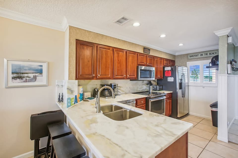 - Modern kitchen with full appliances including fridge, stove, and microwave  
- Counter seating adds extra dining options for family and guests  
- Convenient design perfect for preparing meals and snacks
