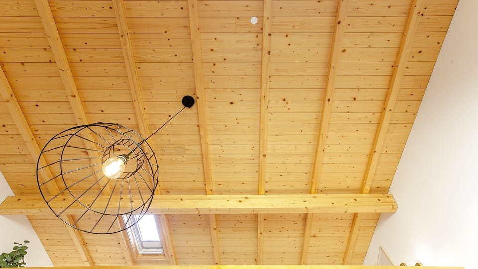 Gaze up at the charming wooden beamed ceiling, illuminated by both a stylish pendant lamp and a natural light-giving skylight. This unique architectural detail adds character and brightness to your stay.