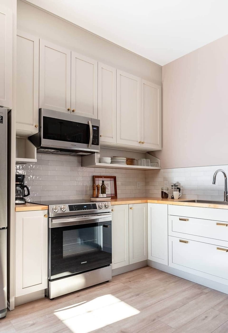 2-South kitchen corner with light grey cabinets, subway tile backsplash, and gold hardware accents.