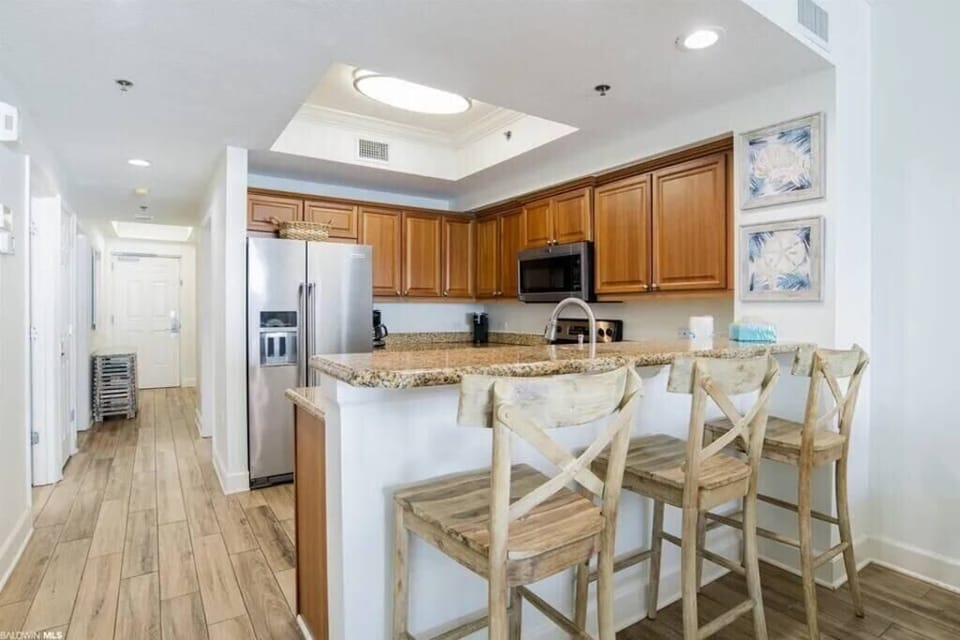 Well equiped kitchen with granite counters and stainless steel appliances.