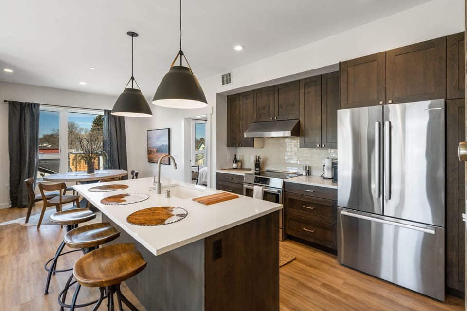 Full kitchen with 3 bar seats available to seat guests at the kitchen island.