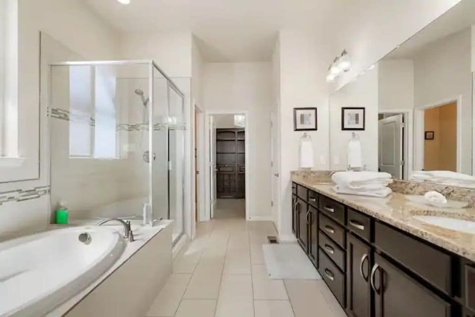 Oversized Master Bathroom equipped with large soaking tub, glass shower and pass through master walk in closet.