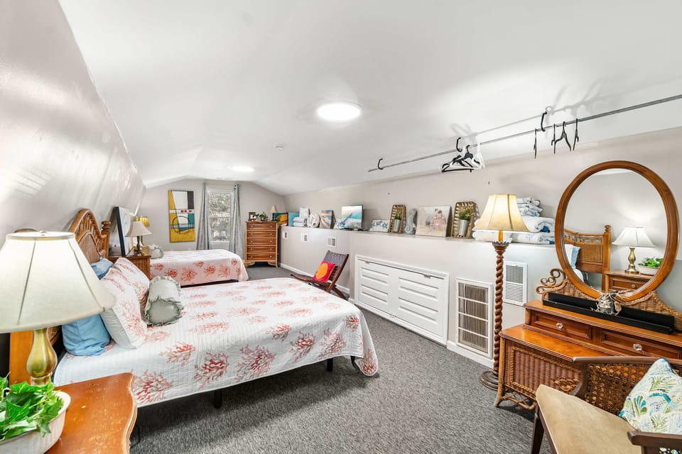 Spacious attic bedroom with two beds and a coastal theme.