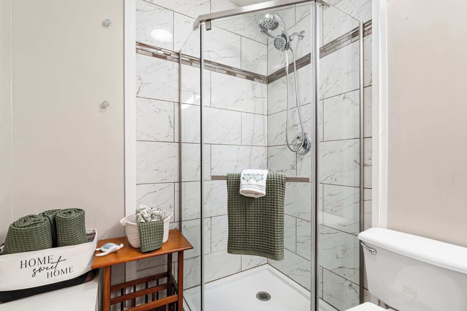 Modern walk-in shower with marble-style tile.