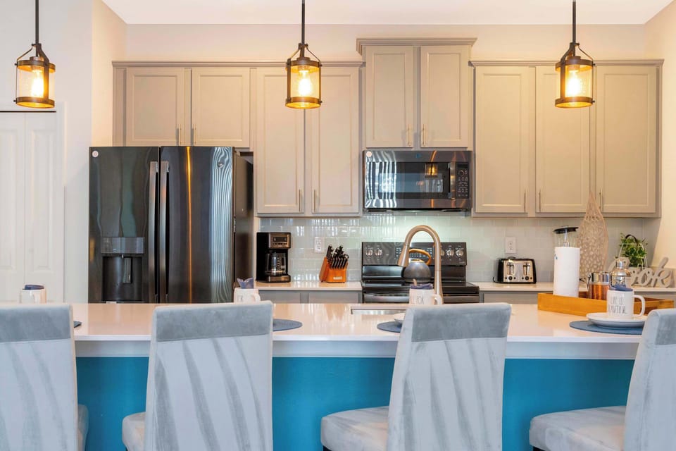Modern and functional, this kitchen boasts high-end black appliances and industrial-style lighting, making it the heart of your vacation home.
