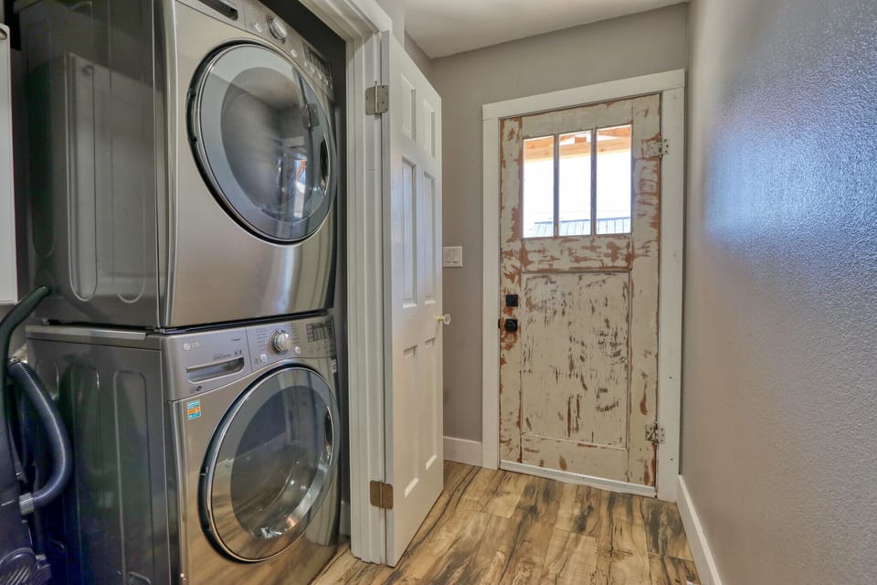 Stacked washer and Dryer by rear door of home.