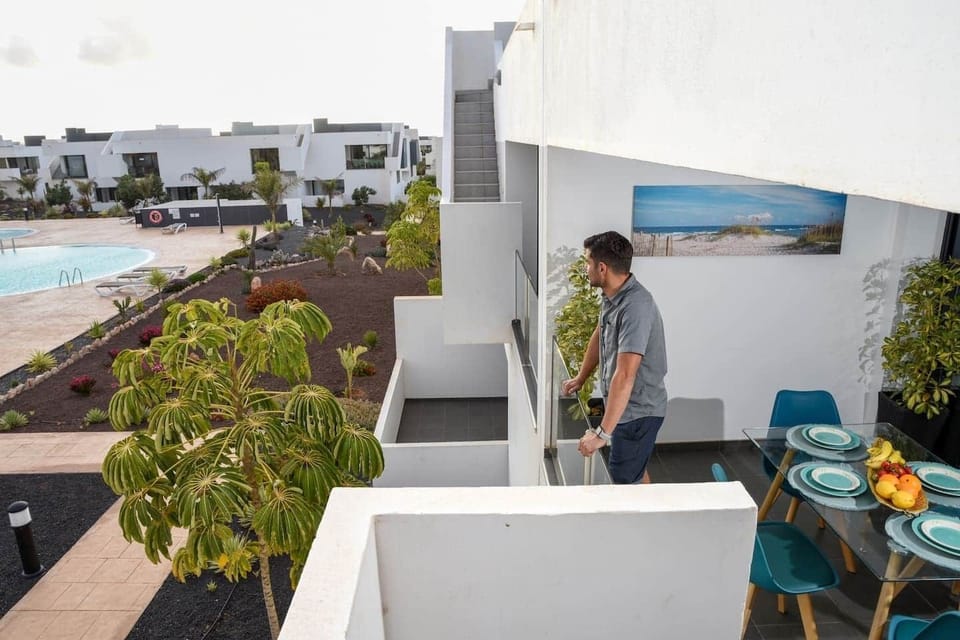 Terraza privada con comedor exterior y agradables vistas a la piscina y jardines del complejo.
