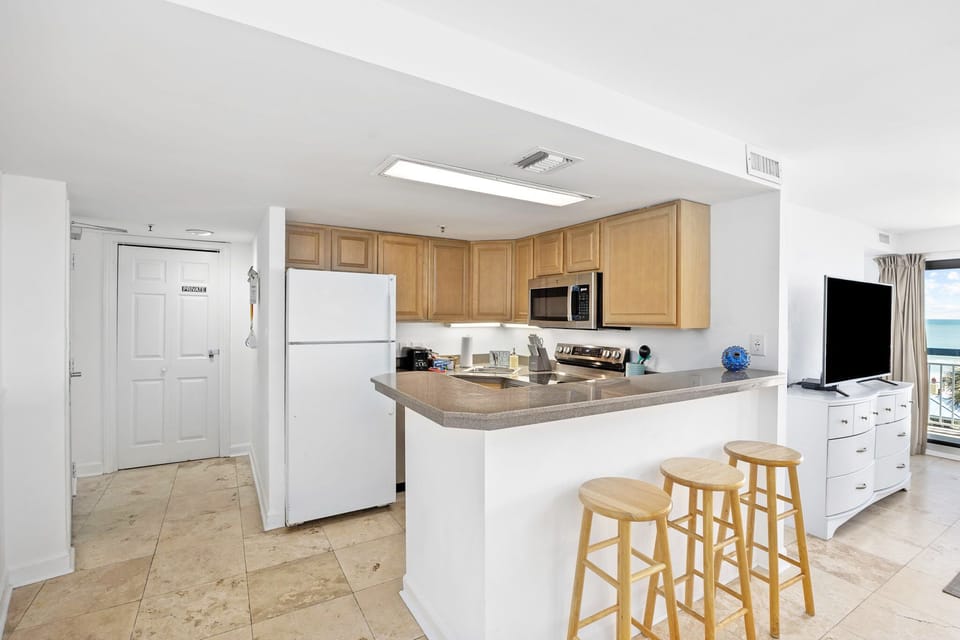 Open kitchen with extra seating at the breakfast bar. 