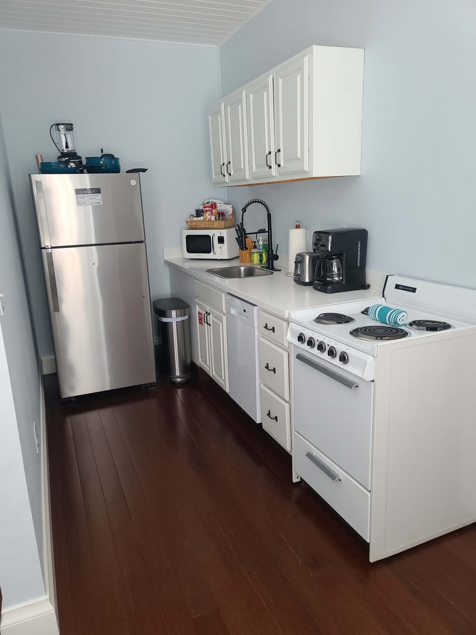 full kitchen with dishes, pots, plates, silverware, utensils, mixing bowls, toaster, blender, microwave, hand soap and dish soap
