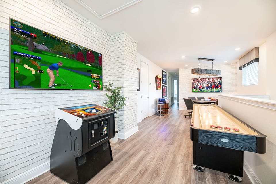 The entertainment loft offers Golden Tee Live, shuffleboard, Pac-Man, a professional poker table, and a wall-mounted Smart TV