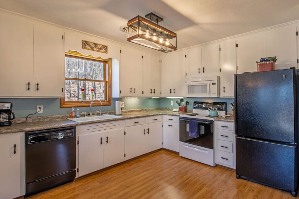 Full kitchen includes a stove top, oven, dishwasher, microwave, coffee pot, and more