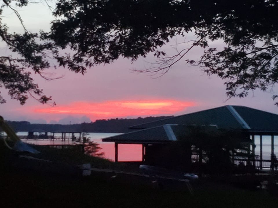 sunset over neighbors' pier from edge of our property to the left