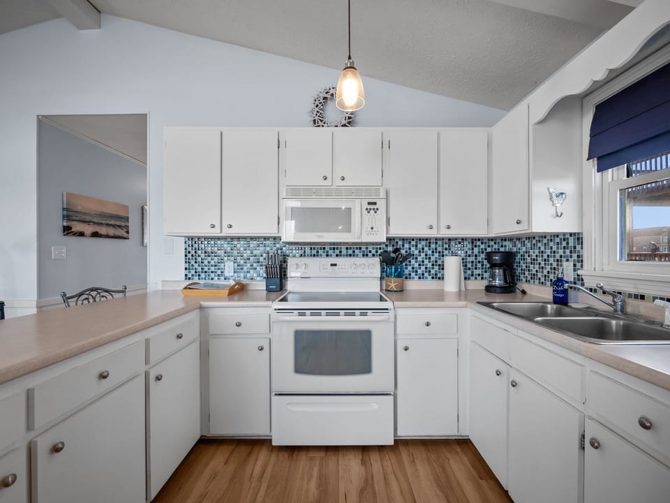 Kitchen with microwave, stove top, and oven.