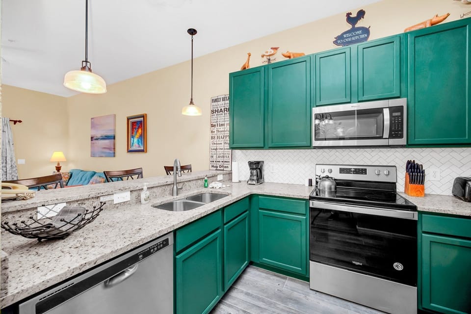 Modern kitchen with stainless steel appliances, granite countertops, and equipped for cooking.