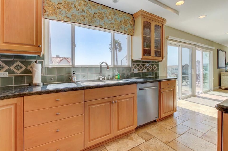 Features a dishwasher and dish supplies. Sink has stunning ocean view.