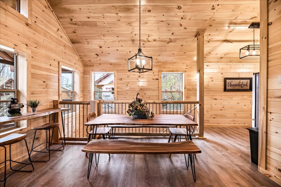 Large dining room table, with two large bench seats and two head chairs.