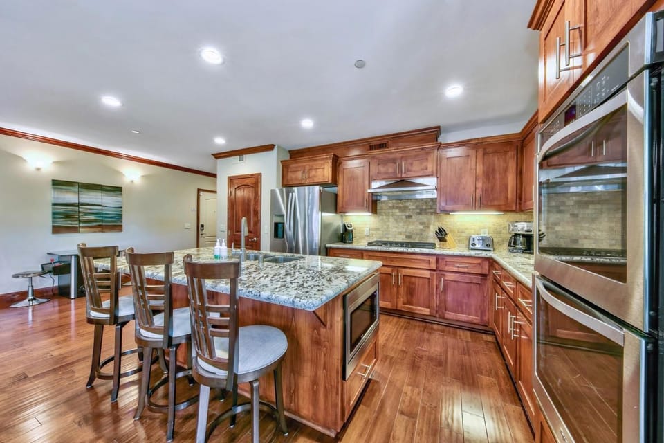 Gather around your granite island to cook memorable meals in this fully equipped gourmet kitchen with rich wood cabinetry and stainless appliances.