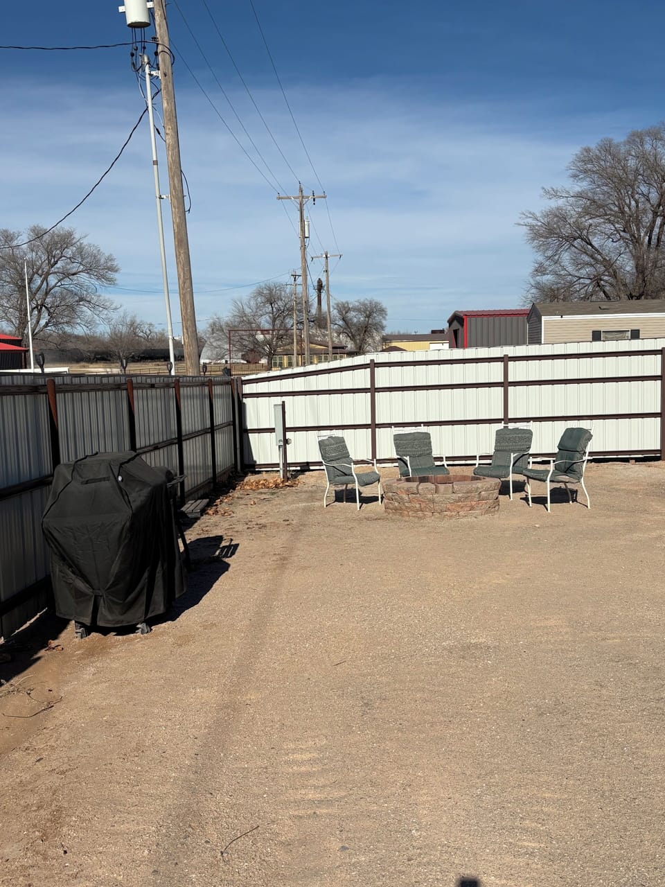 Fire pit with chairs and gas grill.