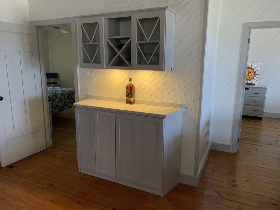 A dry bar give your storage for your adult libations with glassware above.