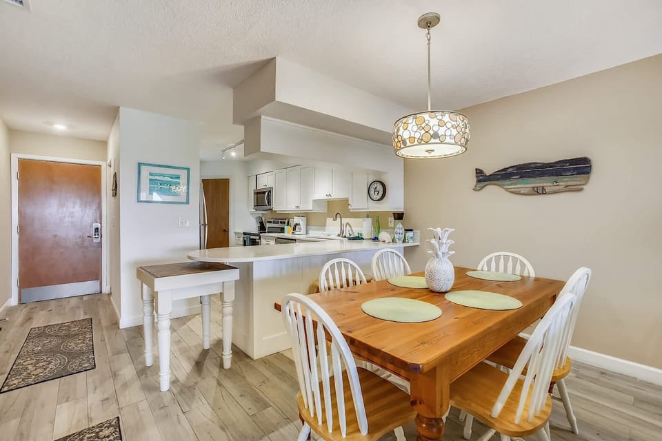 - Gather for meals at this wood dining table with seating for six, accented by chic lighting
- Coastal wall art and decor bring a casual beach vibe to the space
- Perfect spot for family dinners, morning coffee, or evening games together