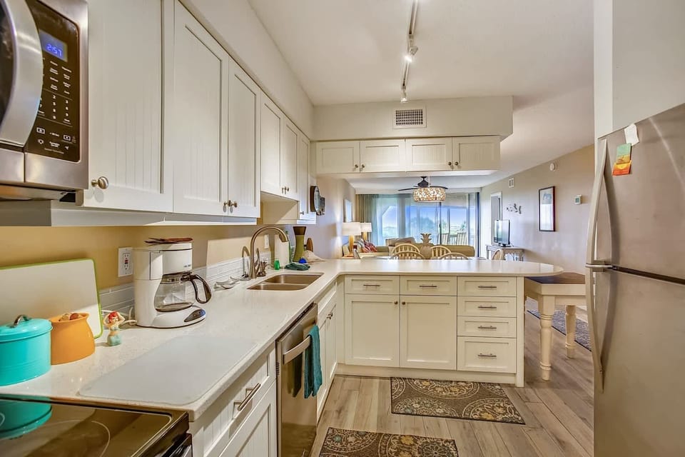 - Wide angle kitchen view highlights generous counter space and breakfast bar seating
- Stainless steel fridge, oven, and sink provide everything needed for cooking
- Open design allows you to cook and still join the fun in the living area