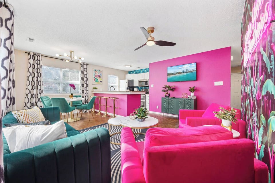 Open kitchen, living room and dining area with smart TV and doors leading to private patio