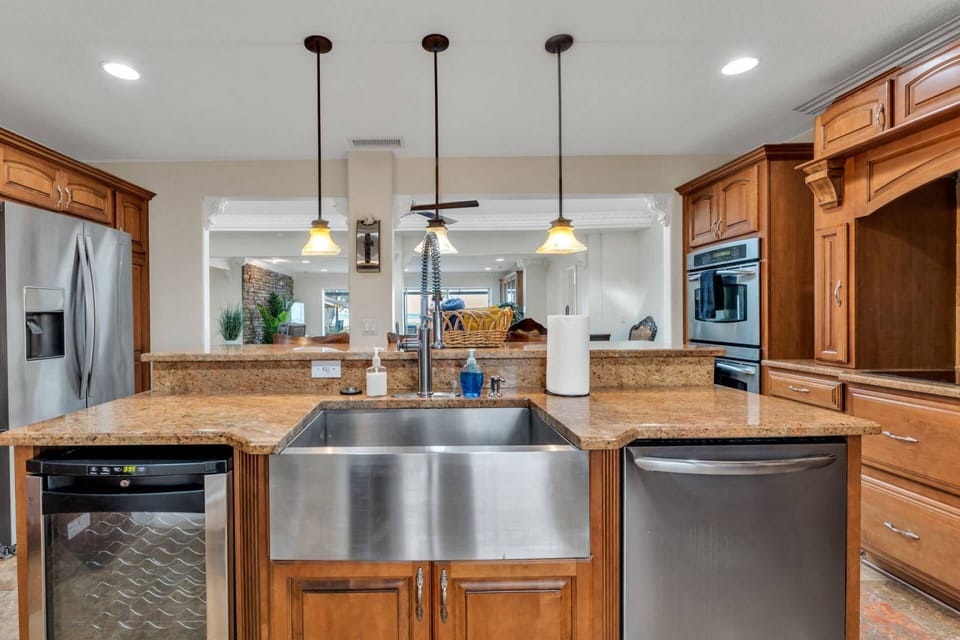 Large kitchen island with farmhouse sink and seating, perfect for casual breakfasts or evening conversations after a day on the water.